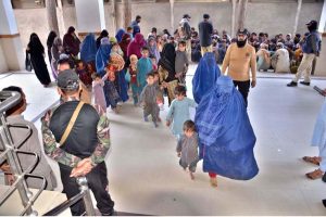 Police personnel registers the names and details of Afghan nationals detained by the district administration for residing illegally