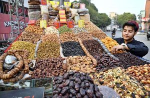 A young vendor arranging and displaying the different kinds of Dry fruits to attract the customers on the roadside setup in the Provincial Capital.