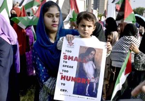 A female member of the Sunni Ulema Council, carrying her child, joins a protest outside the National Press Club against the Israeli attack on an aid convoy for Palestinians and the arrest of former Senator Mushtaq Ahmed along with members of the International Sumud Flotilla.