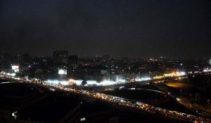 A breathtaking panoramic view of Karachi’s skyline captured from the rooftop of a high-rise building, showcasing the city’s vibrant urban landscape under the evening light.
