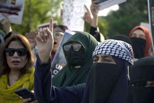 A female member of the Sunni Ulema Council, carrying her child, joins a protest outside the National Press Club against the Israeli attack on an aid convoy for Palestinians and the arrest of former Senator Mushtaq Ahmed along with members of the International Sumud Flotilla.
