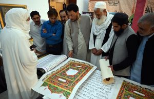 Women displaying Islamic calligraphy artwork during the 3rd Pakistan Hajj & Umrah Exhibition 2025 at Pak-China Friendship Centre