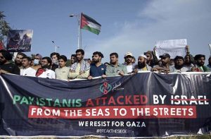 A female member of the Sunni Ulema Council, carrying her child, joins a protest outside the National Press Club against the Israeli attack on an aid convoy for Palestinians and the arrest of former Senator Mushtaq Ahmed along with members of the International Sumud Flotilla.