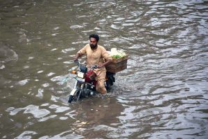 A motorcyclist passing through stagnant rain water accumulated at Nishatabad after heavy rain in the city.