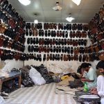 Cobbler preparing traditional shoes (Peshawari Chappal) to the customers at his workplace in the Provincial Capital