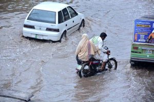 A motorcyclist passing through stagnant rain water accumulated at Nishatabad after heavy rain in the city.