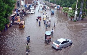A motorcyclist passing through stagnant rain water accumulated at Nishatabad after heavy rain in the city.