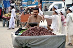 A vendor arranging and displaying mobile phone accessories to attract the customers at his roadside setup in the City
