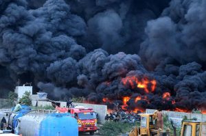 A view of thick smoke rises after fire broke out in a tyre warehouse in Mowach Goth area.