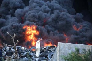 A view of thick smoke rises after fire broke out in a tyre warehouse in Mowach Goth area.
