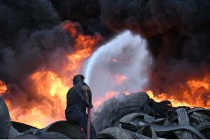 A view of thick smoke rises after fire broke out in a tyre warehouse in Mowach Goth area.