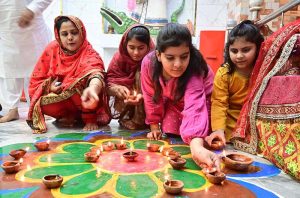 Girls from the Hindu community lighting lamps during the Diwali festival at Durga Shiv Mandir in GOR Colony.