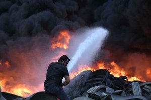 A view of thick smoke rises after fire broke out in a tyre warehouse in Mowach Goth area.