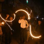 Hindu community boys celebrating Diwali festival by lighting sparklers in connection with the festival of lights.