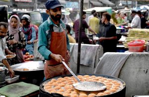 A vendor prepares the traditional delicacy ‘Laddu Peethi’ to serve customers at his roadside stall in the city.