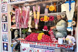 A vendor preparing flower garlands for customers at F-6 area in the Federal Capital