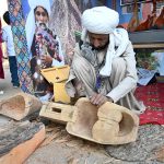 An artisan makes a musical instrument at Ten-Day annual folk festival “Lok Mela 2025” at Lok Virsa