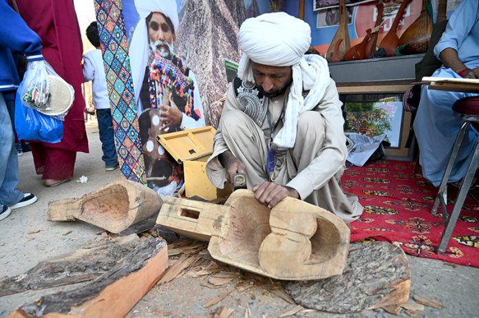 An artisan makes a musical instrument at Ten-Day annual folk festival “Lok Mela 2025” at Lok Virsa