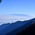 A breathtaking panorama from Nathiagali, where the rolling Murree Hills lead the eye toward the distant Kashmir Mountain range rising in the far background