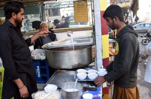 A shopkeeper serves pink tea to customers as demand rises with the onset of winter