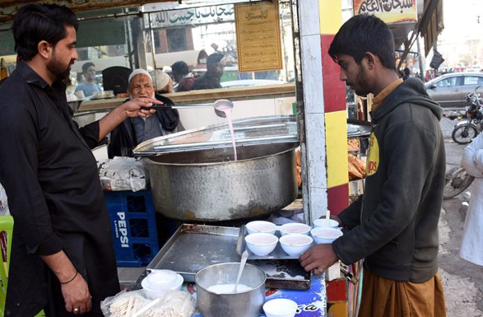A shopkeeper serves pink tea to customers as demand rises with the onset of winter