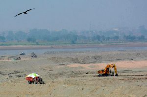 Soil is being removed with the help of a crane after the flood in the Ravi River.