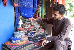 A vendor preparing flower garlands for customers at F-6 area in the Federal Capital