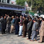 “People stand in a queue to install E-tags/M-tags for their vehicles at Kachnar Park
