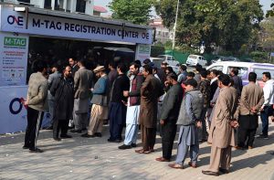 “People stand in a queue to install E-tags/M-tags for their vehicles at Kachnar Park