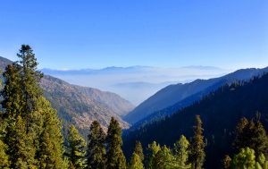 A breathtaking panorama from Nathiagali, where the rolling Murree Hills lead the eye toward the distant Kashmir Mountain range rising in the far background