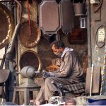 A worker busy polishing brass items at his workplace to attract customers at Bhabra Bazaar area in the city