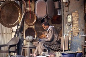 A worker busy polishing brass items at his workplace to attract customers at Bhabra Bazaar area in the city