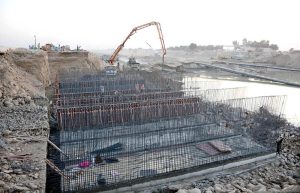 Labourers busy in reconstruction work of the M5 Motorway after being damaged by flooding while heavy machinery and workers reinforce the structure at the site at Jalalpur Pirwala.