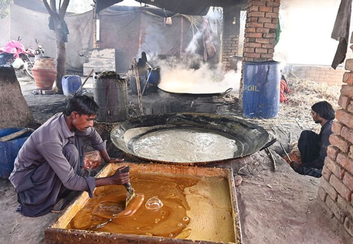 A labourer prepares jaggery from sugarcane at his workplace along Mirpurkhas Road