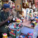 An artisan paints truck art on different display tools at Ten-Day annual folk festival “Lok Mela 2025” at Lok Virsa