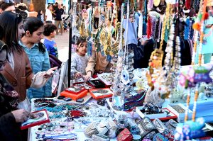 An artisan paints truck art on different display tools at Ten-Day annual folk festival “Lok Mela 2025” at Lok Virsa