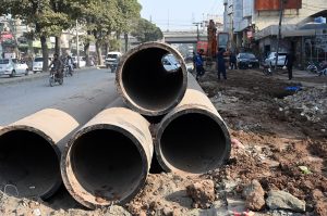 Laborer busy digging for installing pipelines on main commercial market road in the city