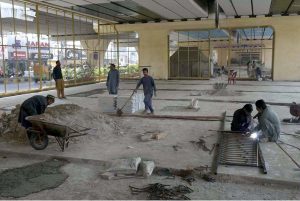 Laborers work on preparing a play area beneath the Sixth Road flyover