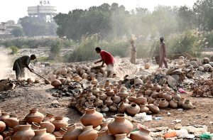 Labourers are busy arranging clay-made pots at their workplace for drying purpose at Kumhar Para.