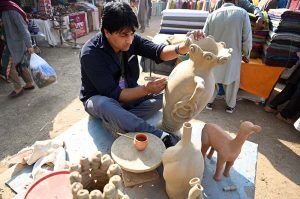 A vendor preparing tradition sajji to attract customers during the ten-day annual folk festival “Lok Mela 2025” at Lok Virsa.