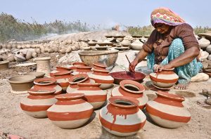 Labourers are busy arranging clay-made pots at their workplace for drying purpose at Kumhar Para.