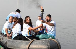Olympian Sadaf Siddiqui, along with other participants, holds the torch during the 35th National Games Torch Relay ceremony at Rawal Lake, Islamabad, organized by the Islamabad Olympic Association