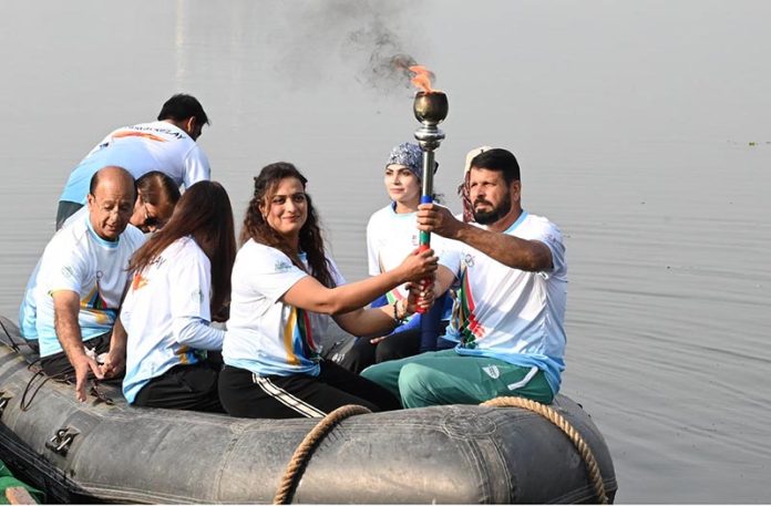 Olympian Sadaf Siddiqui, along with other participants, holds the torch during the 35th National Games Torch Relay ceremony at Rawal Lake, Islamabad, organized by the Islamabad Olympic Association
