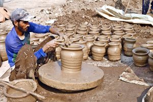Labourers are busy arranging clay-made pots at their workplace for drying purpose at Kumhar Para.