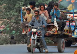 A gypsy family traveling on a tricycle rickshaw heading towards their destination.