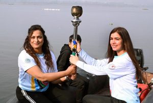 Olympian Sadaf Siddiqui, along with other participants, holds the torch during the 35th National Games Torch Relay ceremony at Rawal Lake, Islamabad, organized by the Islamabad Olympic Association