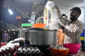 A street vendor is selling hot chicken soup to customers as demand rises with the onset of winter.