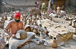 Labourers are busy arranging clay-made pots at their workplace for drying purpose at Kumhar Para.