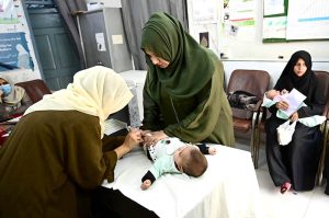 A lady health worker administers vaccine to a child at C.D.F Hospital during the National Measles and Rubella Prevention Campaign underway in the city