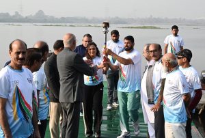 Olympian Sadaf Siddiqui, along with other participants, holds the torch during the 35th National Games Torch Relay ceremony at Rawal Lake, Islamabad, organized by the Islamabad Olympic Association
